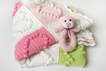 Knitted baby blanket with decorations in heart shape