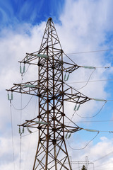 Pylons of high-voltage power lines and a blue sky with clouds