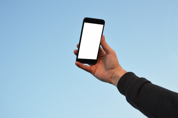 Male hand holding smart phone at the sky background with clipping path