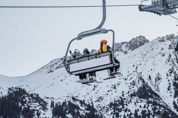 People sitting in the ski lift in Shymbulak ski resort in Kazakhstan