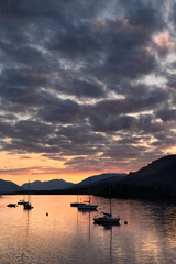 Red Sunset with clouds on Loch Leven with moored sailboats at Glencoe Boat Club Scottish Highlands Scotland UK