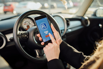 Girl using smartphone app to pay for the parking.