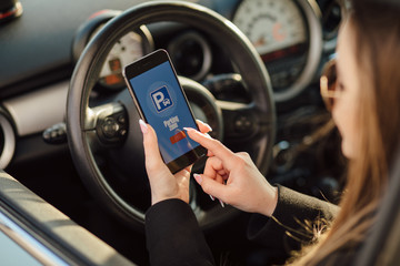 Girl using smartphone app to pay for the parking.
