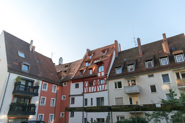 A view on Kaiserburg Castle district living houses with unusual architecture window elements in white peach in Nuremberg at dawn in the morning