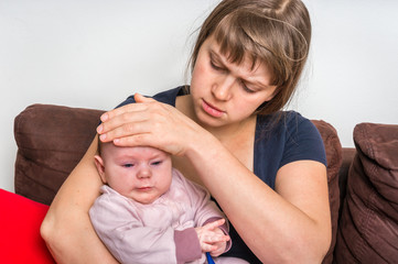 Infant baby with fever and worried mother with thermometer
