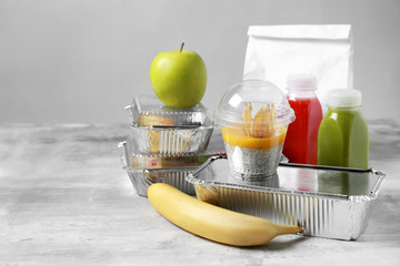 Containers with delicious food on table