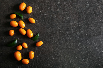 Fototapeta na wymiar Delicious kumquat fruit on dark table