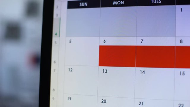 Person scheduling few days in online diary with red color, holidays, vacation