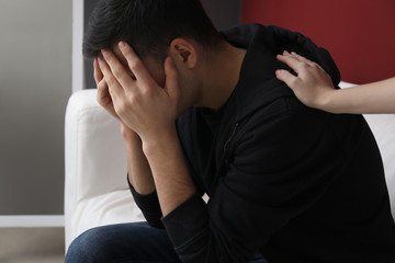 Woman calming depressed male suicider at home