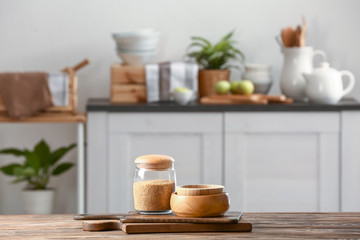 Jar with seeds, bowls and boards on kitchen table