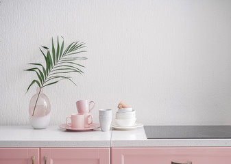 Set of tableware and modern stove in kitchen