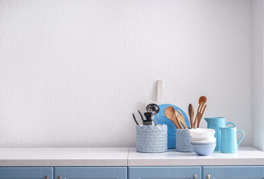 Set of kitchenware on table near white wall