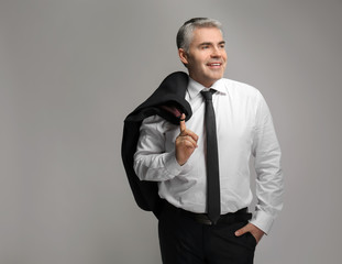 Handsome mature businessman on grey background