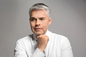 Fototapeta premium Handsome mature businessman on grey background