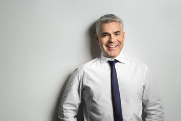 Handsome mature businessman on grey background