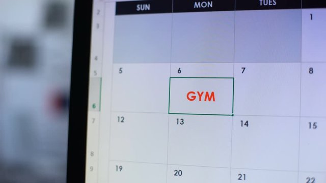 Person planning visit to gym, making note in online calendar, healthy lifestyle