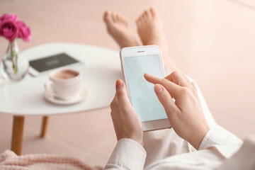 Young woman using mobile phone at home