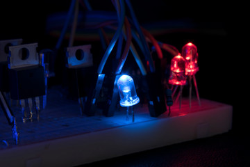 breadboard arduino nano prototyping board transistors resistors LEDs red and blue in glow in the...
