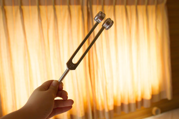 Hand holding a tuning fork .