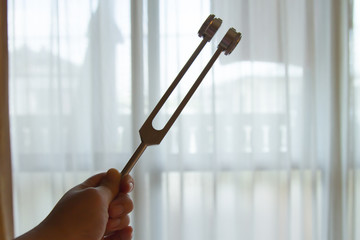 Hand holding a tuning fork .