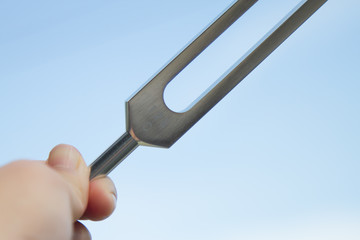 Hand holding a tuning fork .