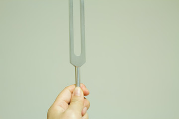 Hand holding a tuning fork .