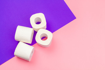 White toilet paper rolls on bright color block background