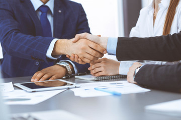 Business people shaking hands, finishing up a papers signing. Meeting, contract and lawyer consulting concept