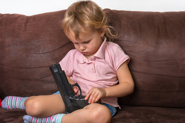 Child is playing with parents pistol - safety concept
