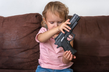 Child is playing with parents gun - safety concept