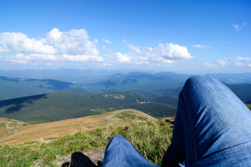 Hikers lay down resting and show feet with wearing shoe at top of mountain.