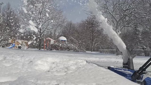 Close up and supper slow motion of a electric snowblower being push into pile of snow after heavy overnight snowfall.
