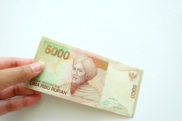  Woman hand holding  Indonesia banknote on white background. 