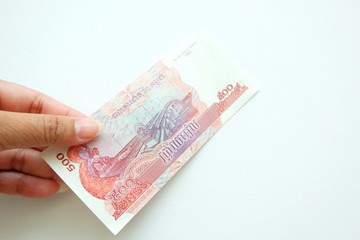 Woman hand holding Cambodia banknote on white background. 