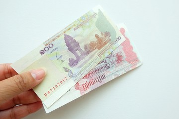Woman hand holding Cambodia banknote on white background. 
