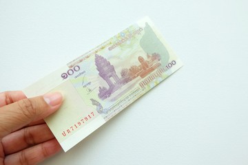 Woman hand holding Cambodia banknote on white background. 