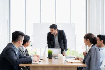 Businesspeople discussing together in conference room during meeting at office.