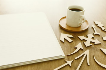 Obraz na płótnie Canvas top view image of open notebook with blank pages next to cup of coffee on wooden table. ready for adding text or mockup