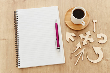 top view image of open notebook with blank pages next to cup of coffee on wooden table. ready for adding text or mockup