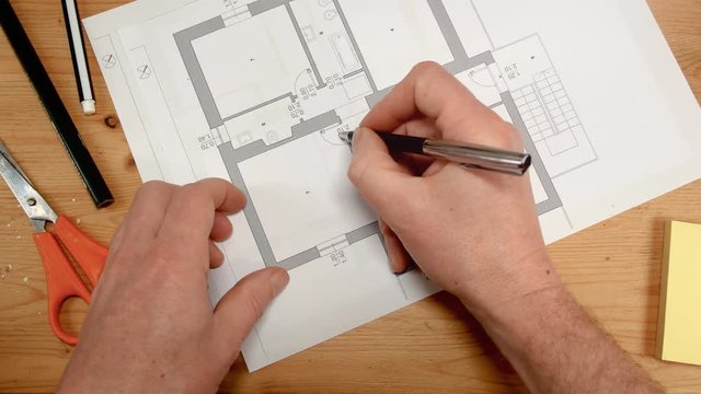 top view, an interior designer's hand draws an ideal map for a new home, footage ideal for topics such as building renovation, design, new home and family