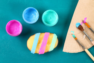Diy Easter eggs made of cardboard and potato stamp, Easter greeting card on green background.