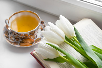 mug of tea, 3 white tulips on the book