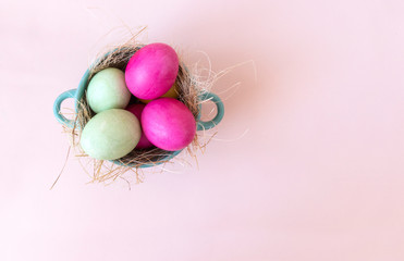 Fototapeta na wymiar pink and green eggs in hay vtarelke top view, beige background, Easter,
