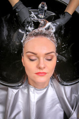 Hairdresser washing woman's hair in hairdresser salon