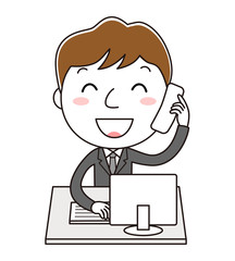 デスクトップパソコンの前で電話対応をしている笑顔の男性社員