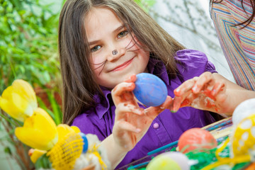 Mother and her children paint easter eggs