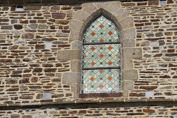 Beautiful stone work wall and stined glass window of a church in France