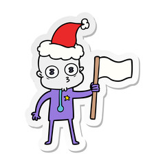 sticker cartoon of a weird bald spaceman with flag wearing santa hat