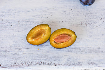 Harvested Fresh blue plums at light wooden background/ Food background/ Flatware