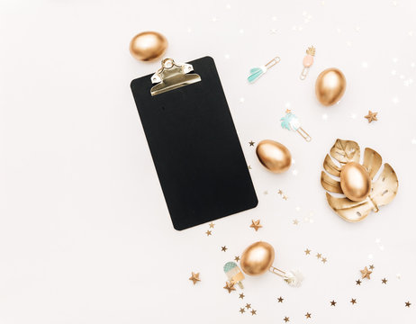 Flat lay Gold Easter eggs with decorations on white background. top view, Minimal Easter holiday concept